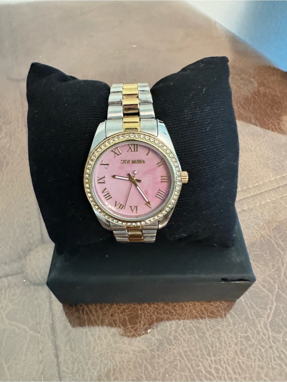 Gold and silver watch with pink background